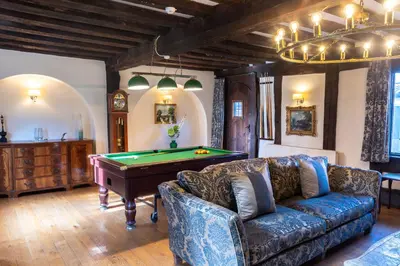 a living room with a couch and a pool table at Amazing Spa Country House with Indoor Pool, Sauna and Steam Room in Tibenham