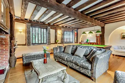 a living room with a couch and a pool table at Amazing Spa Country House with Indoor Pool, Sauna and Steam Room in Tibenham