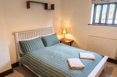 a bedroom with a bed with two towels on it at Amazing Spa Country House with Indoor Pool, Sauna and Steam Room in Tibenham