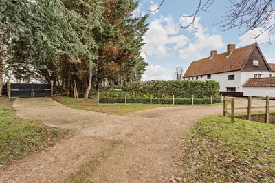a dirt road in front of a house at Amazing Spa Country House with Indoor Pool, Sauna and Steam Room in Tibenham