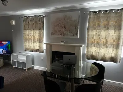 a living room with a table and a fireplace at Ipswich-Luxury-Self Catering-Town Centre-Parking in Ipswich