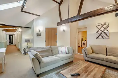 a living room with two couches and a table at 2 Bed Barn conversion in Tibenham