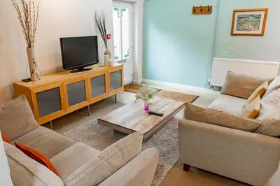 a living room with two couches and a tv at 2 Bed Barn conversion in Tibenham