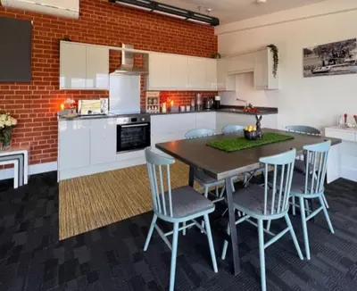 a kitchen with a wooden table and chairs in it at Withers Farm Apartments in Mount Bures
