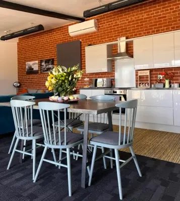 a kitchen with a table and chairs in a kitchen at Withers Farm Apartments in Mount Bures