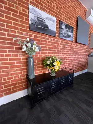 a brick wall with two vases and flowers on a table at Withers Farm Apartments in Mount Bures
