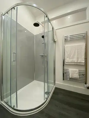 a bathroom with a shower with a glass enclosure at Withers Farm Apartments in Mount Bures