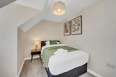 a small bedroom with a bed and a lamp at The Grange Luxe2, 5 Bedroom House,Spacious,contractor,family,Internet,free parking,group,study,relocation,easily accessible in Ipswich,Kesgrave in Ipswich