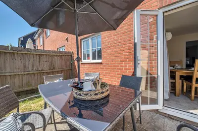 a table with an umbrella on a patio at The Grange Luxe3, 4 Bedroom House,5-beds,Spacious,contractor,family,Internet,free parking,group,study,relocation,easily accessible in Ipswich,Kesgrave in Ipswich