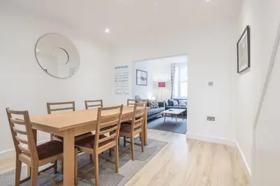 a dining room with a wooden table and chairs at Refurbished High Spec CENTRAL Family Home in Cambridge