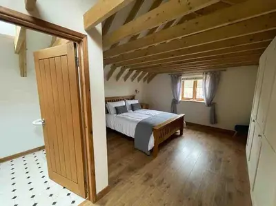 a bedroom with a bed and a wooden ceiling at Charming Norfolk Barn Conversion in Barnham Broom in Norwich