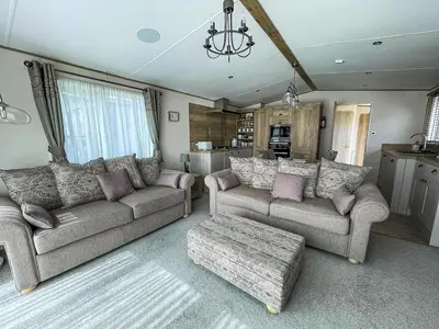 a living room with two couches and a table at Modern Caravan With Large Decking Area, Ref 60057Ch in Saxmundham