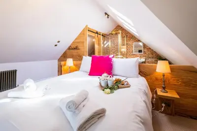 a bedroom with a white bed with towels on it at Alde Bay Farm - Barn Owl Sanctuary in Aldeburgh