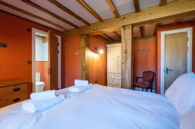 a large white bed in a room with orange walls at Alde Bay Farm - Barn Owl Sanctuary in Aldeburgh