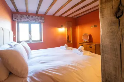 a bedroom with a large white bed with a window at Alde Bay Farm - Barn Owl Sanctuary in Aldeburgh