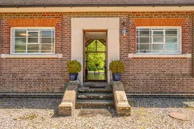 a brick house with stairs leading to a door at Ultimate Constable Country rural retreat - The Pump House in Colchester