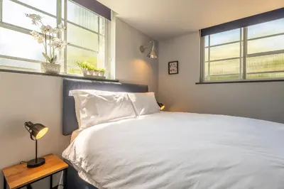 a bedroom with a white bed and two windows at Ultimate Constable Country rural retreat - The Pump House in Colchester