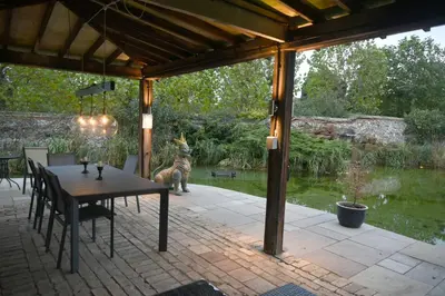 a patio with a table and a dog in the background at The Mill B&B in Thetford