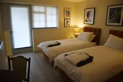 a bedroom with two beds and a window at The Mill B&B in Thetford