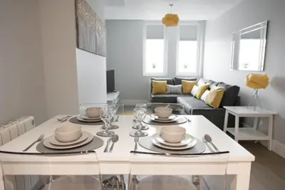 a living room with a table with dishes on it at S/KING BED ONE BEDROOM FLAT in Brentwood