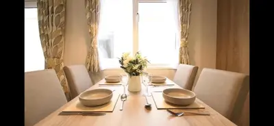 a wooden table with two bowls on top of it at Coopers Beach 3-Bed Caravan Sleeps 8 & Pets Ok in Colchester