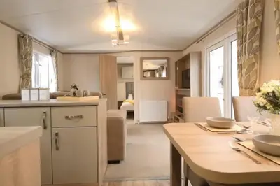 a kitchen and living room with a table and a dining room at Coopers Beach 3-Bed Caravan Sleeps 8 & Pets Ok in Colchester