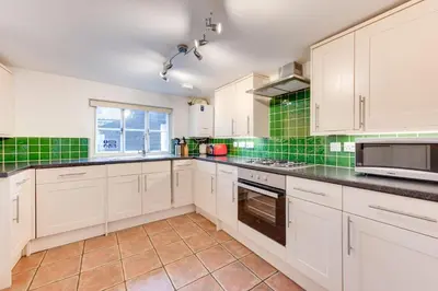 a kitchen with white cabinets and green tiles at 3 Bed in Aldeburgh oc-chfc in Aldeburgh