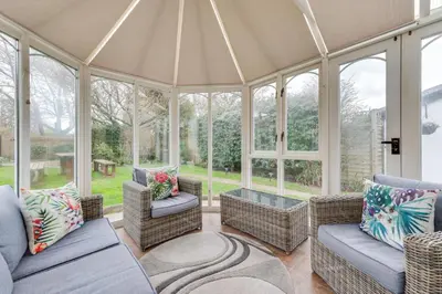 a conservatory with couches and chairs and windows at 3 Bed in Aldeburgh oc-chfc in Aldeburgh