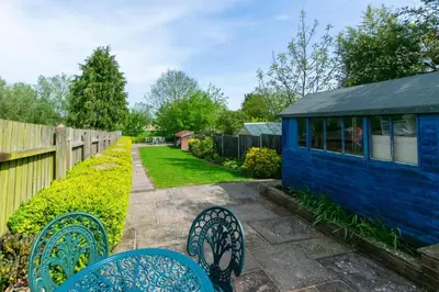 a patio with chairs and a blue house at 3 Bed in Middleton oc-fdp in Middleton