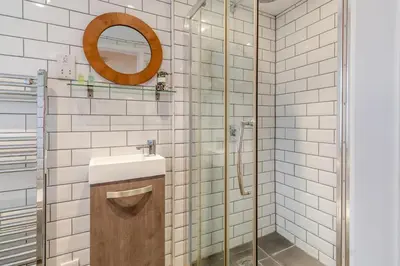 a bathroom with a shower with a sink and a mirror at 3 Bed in Middleton oc-fdp in Middleton