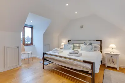 a white bedroom with a large bed with blue pillows at 2 Bed in Sudbury oc-clo in Sudbury