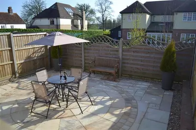 a patio with a table and chairs and an umbrella at 2 Bed in Sudbury oc-clo in Sudbury