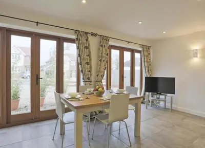 a dining room with a table and chairs and a television at 2 Bed in Sudbury oc-clo in Sudbury
