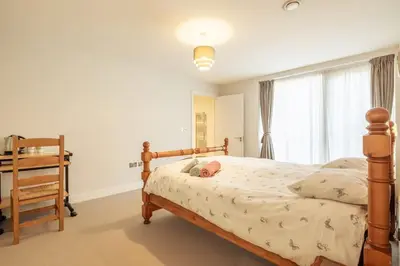 a bedroom with a wooden bed and a window at Luxury Ensuite Room 2 Minutes from Cambridge Station in Cambridge
