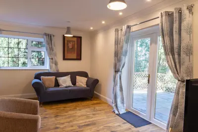 a living room with a couch and a sliding glass door at The Lodge at Highlands in Everton