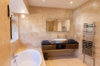 a bathroom with a tub and a sink and a mirror at The Lodge at Highlands in Everton