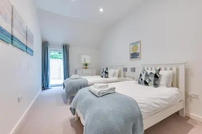 a white bedroom with two beds and a window at 3 Bed in Snape oc-1wadd in Snape