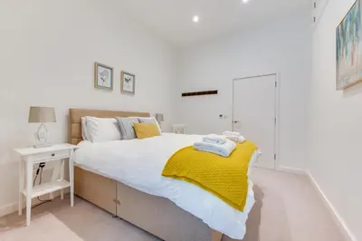 a bedroom with a bed with a yellow blanket on it at 3 Bed in Snape oc-1wadd in Snape