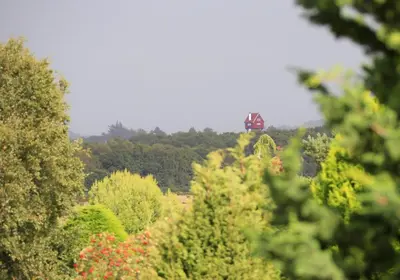 a tractor is driving through a forest of trees at 3 Bed in Aldeburgh oc-10nw in Aldeburgh