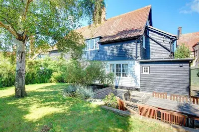 a blue house with a bench in the yard at 5 Bed in Thorpeness oc-whin2 in Thorpeness