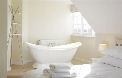 a white bathroom with a tub and a bed at 5 Bed in Thorpeness oc-whin2 in Thorpeness