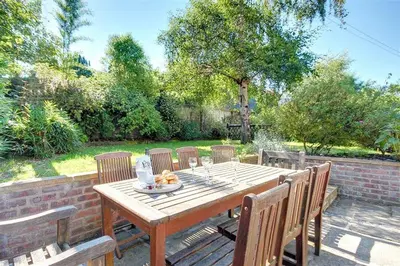 a wooden table and chairs on a patio at 5 Bed in Thorpeness oc-whin2 in Thorpeness