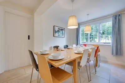 a dining room with a wooden table and chairs at 5 Bed in Thorpeness oc-whin2 in Thorpeness