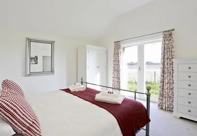 a bedroom with a bed and a large window at 3 Bed in Snape oc-2wadd in Snape