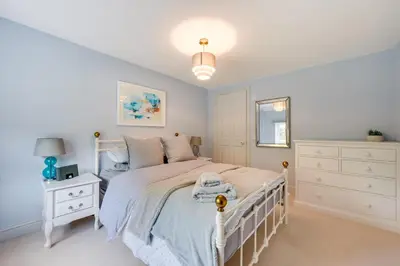 a bedroom with a white bed and a white dresser at 4 Bed in Halesworth oc-5river in Halesworth
