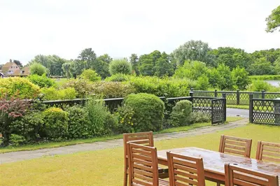 a wooden table and chairs in a garden at 4 Bed in Thorpeness oc-bays in Thorpeness