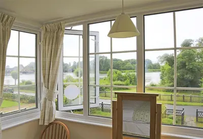 a room with large windows with a view of a river at 4 Bed in Thorpeness oc-bays in Thorpeness