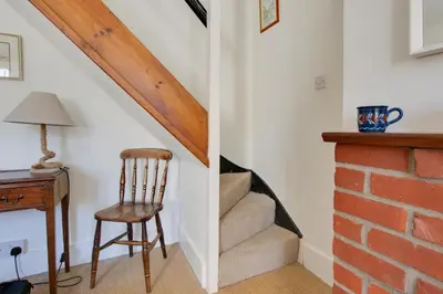 a stairway with a chair next to a brick wall at 2 Bed in Aldeburgh oc-prd in Aldeburgh