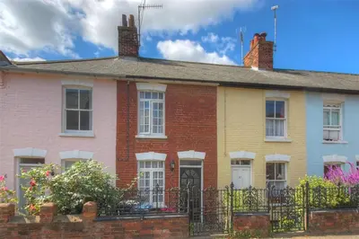 a colorful house with a fence in front of it at 2 Bed in Aldeburgh oc-prd in Aldeburgh