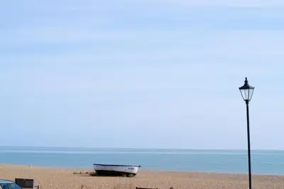 a boat on the beach next to a light pole at 3 Bed in Aldeburgh oc-9king in Aldeburgh